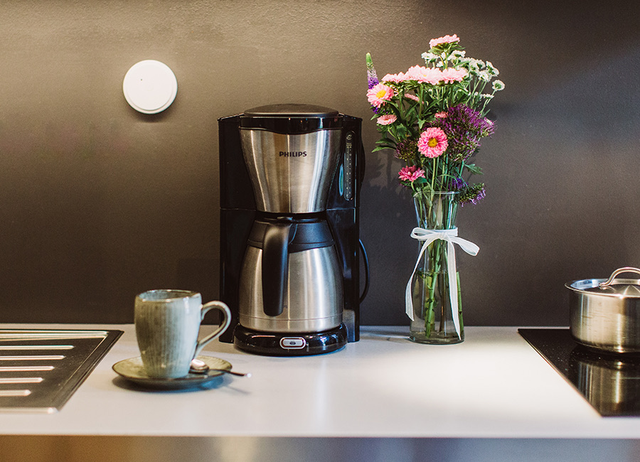 Küchenzeile mit Kaffeemaschine und Blumen